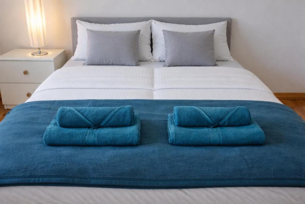 a large bed with two blue pillows on it at Pensjonat Kowalski in Łubowo