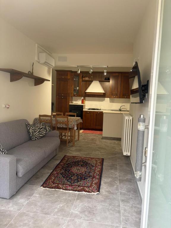 ein Wohnzimmer und eine Küche mit Sofa und Tisch in der Unterkunft Da Mingo in Rosciano