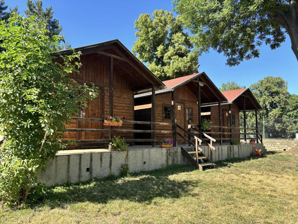 a wooden cabin in a field with a tree at Camp Litomerice in Litoměřice