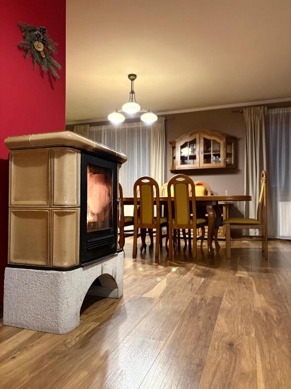 a living room with a fireplace and a dining room at Dom pod Jaworem in Rajcza