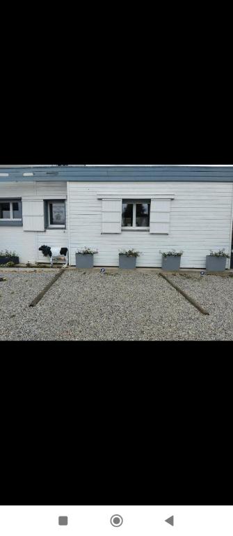 a white building with plants in front of it at Appartement a la Campagne in Radinghem-en-Weppes