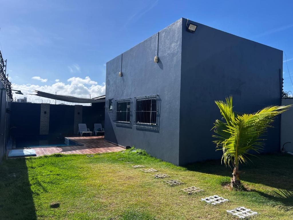 a house with a palm tree in front of it at Casa de Férias com Piscina in Salinópolis