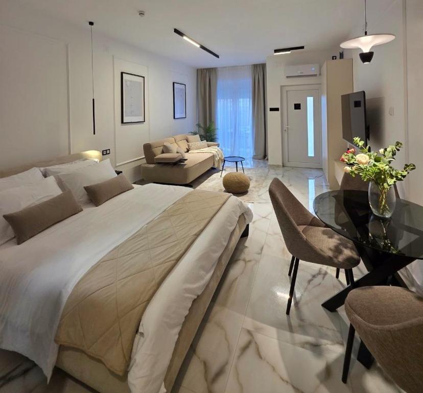 a large bedroom with a large bed and a glass table at Sotto Il Sole in Surčin