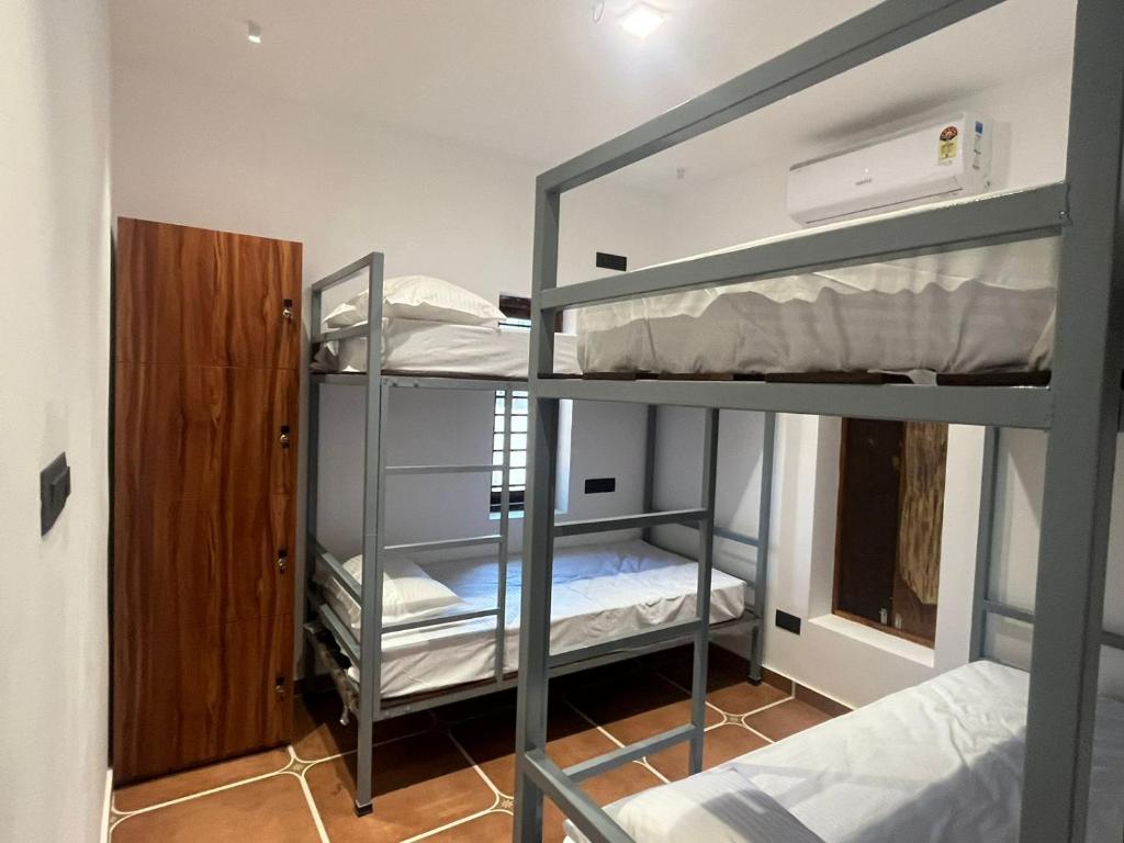 a room with two bunk beds and a door at Hostel Akeeka in Alleppey