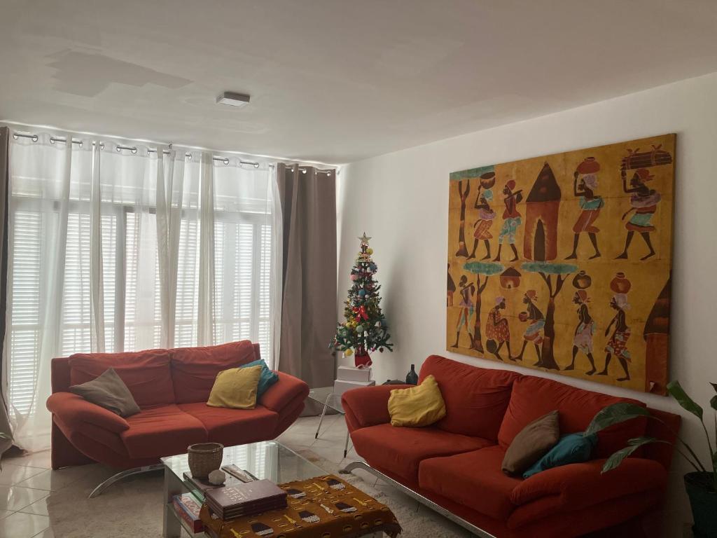 un soggiorno con due divani rossi e un albero di Natale di AkyaSpot a Praia