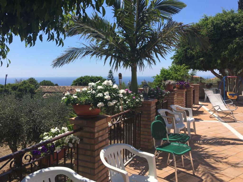 a group of white chairs and a fence with flowers at Le Quattro Sorelle in Saline Joniche