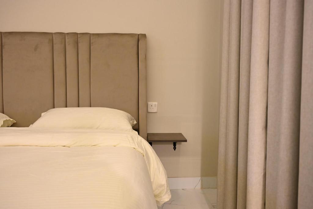 a bedroom with a bed and a curtain at شقق وغرف الرصف in Hail
