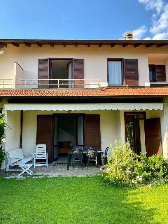 a house with chairs and a table in the yard at La casa di a-mici in Maccagno Superiore