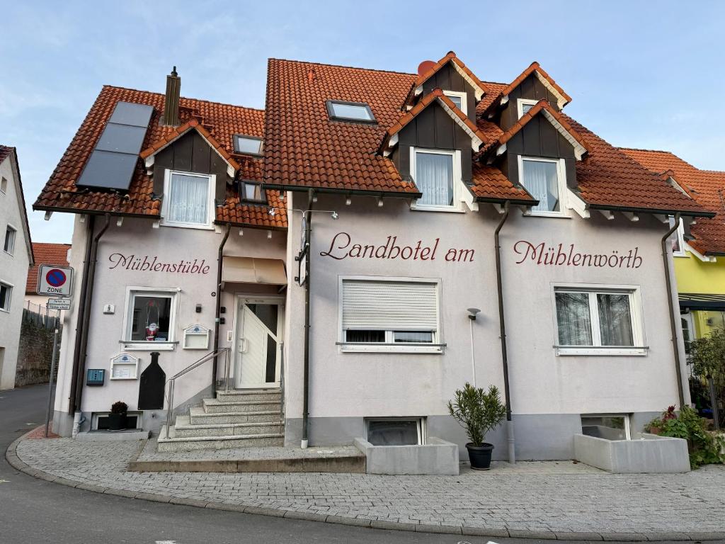 a white house with words on the side of it at Landhotel am Mühlenwörth in Tauberbischofsheim