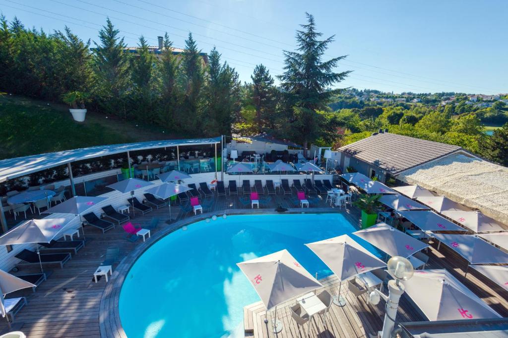 an overhead view of a swimming pool with umbrellas and tables at Hotel Du Golf in Saint-Étienne