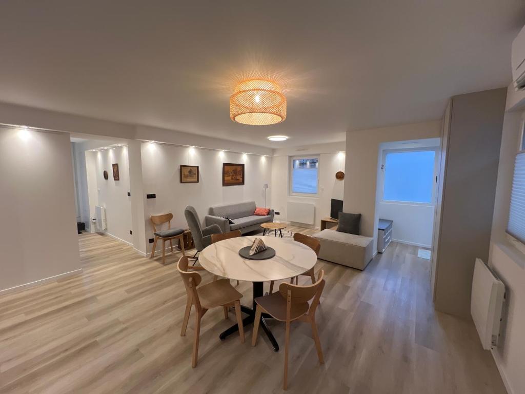 a living room with a table and chairs and a couch at Maison climatisée indépendante et de plein pied in Bischoffsheim
