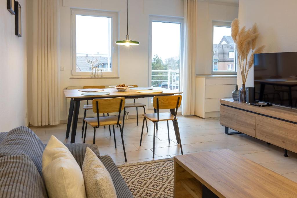 a living room with a couch and a table with chairs at Ferienwohnung Allegra in Heinsberg