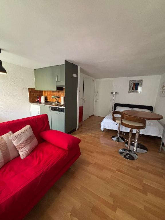 a living room with a red couch and a table at Cooles Apartment an der Kathedrale in Fribourg