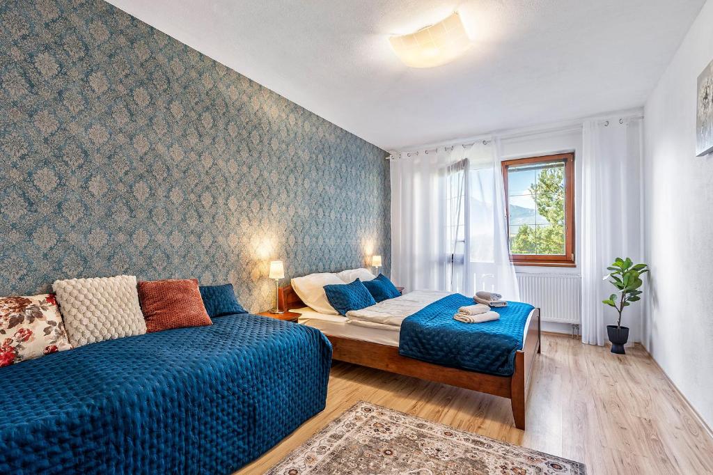 a bedroom with a bed and a couch and a window at Apartment Katry with Tatry View & Balcony in Veľká Lomnica