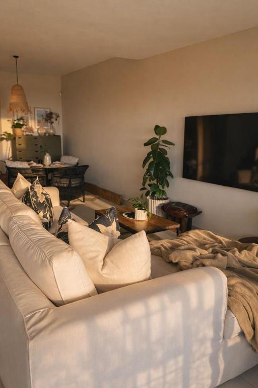 a living room with a white couch and a flat screen tv at Salt & Still in Freeland Park