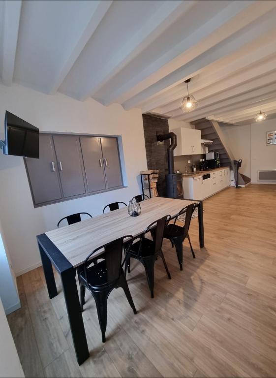 a large wooden table with chairs in a room at Gîte 6 personnes Chez Max in Nébouzat