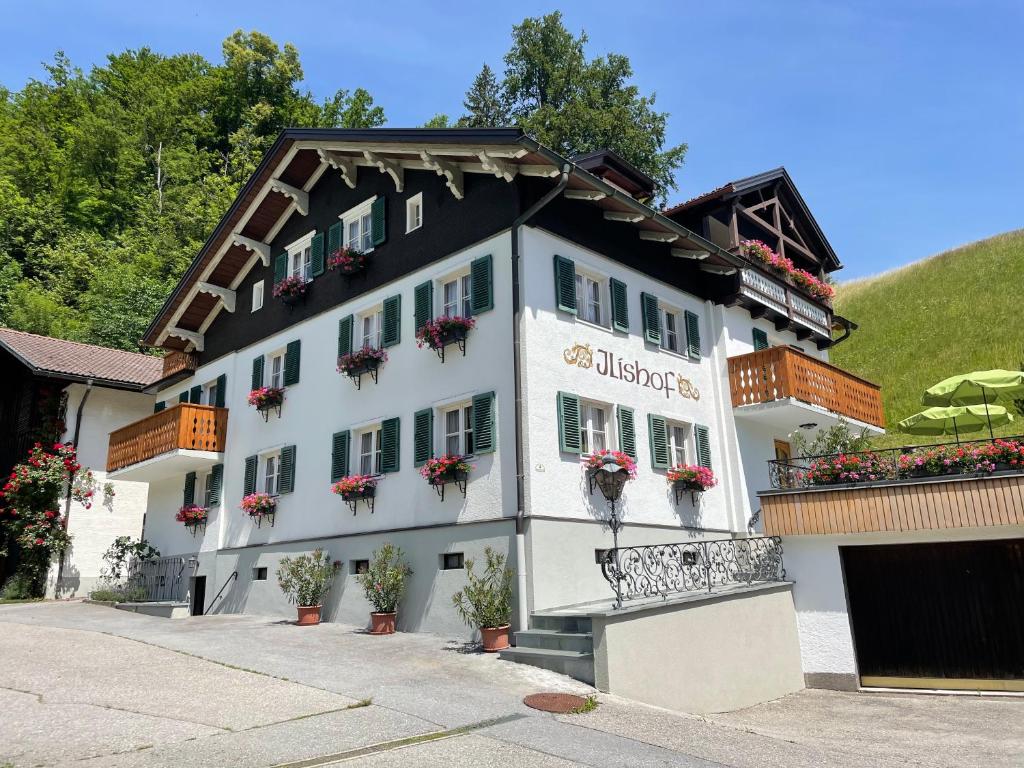 a white building with potted plants on it at Gästehaus Ilishof in Tschagguns