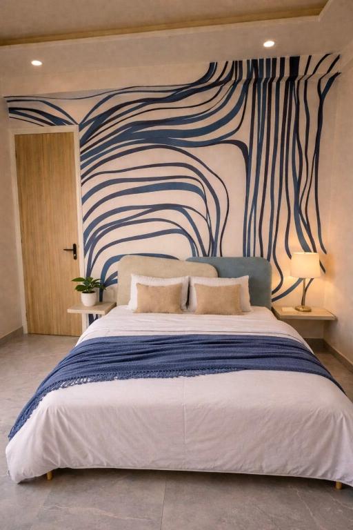 a bedroom with a large bed with a painting on the wall at Chèrie Blueleaf in Jaipur