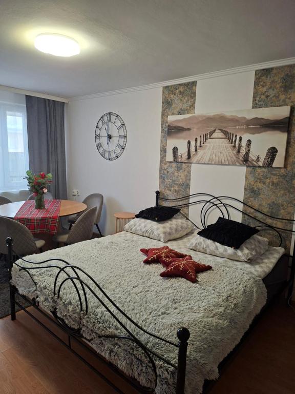 a bedroom with a bed with a clock on the wall at Apartament Diselvio in Nowy Targ