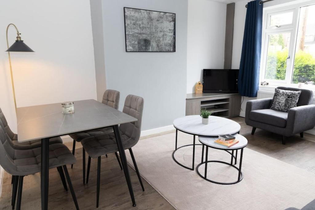 a living room with a dining room table and chairs at The Standhouse Radcliffe in Radcliffe