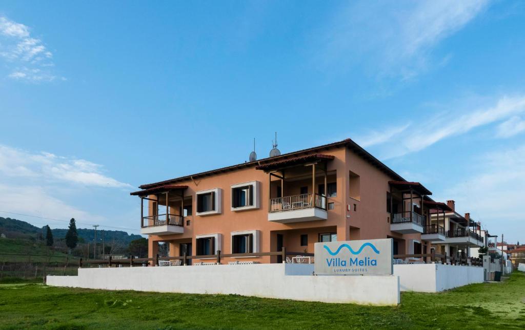 a building with a sign in front of it at Villa Melia Luxury Suites in Ierissos