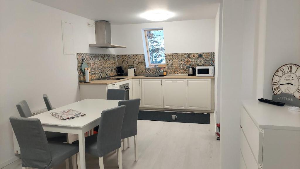 a kitchen with a table and chairs and a clock at Moonriver Alps Ski Apartament in Ramingstein