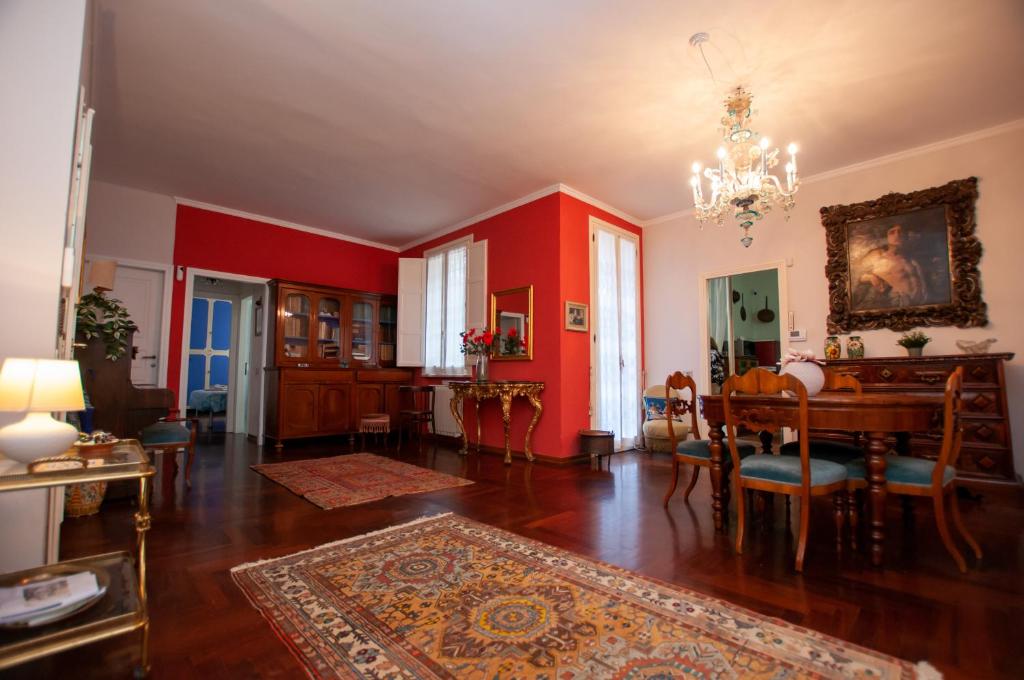 a living room with red walls and a table and chairs at Cristallo apartment in Ravenna