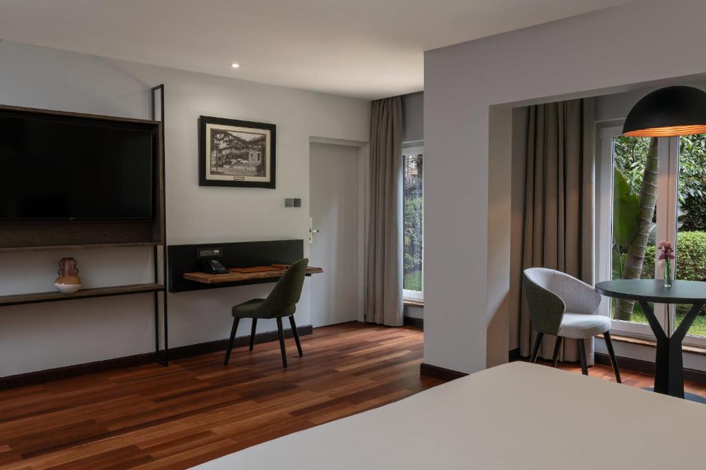 a hotel room with a bed and a table and chairs at Fairview Hotel Nairobi, Vignette Collection by IHG in Nairobi