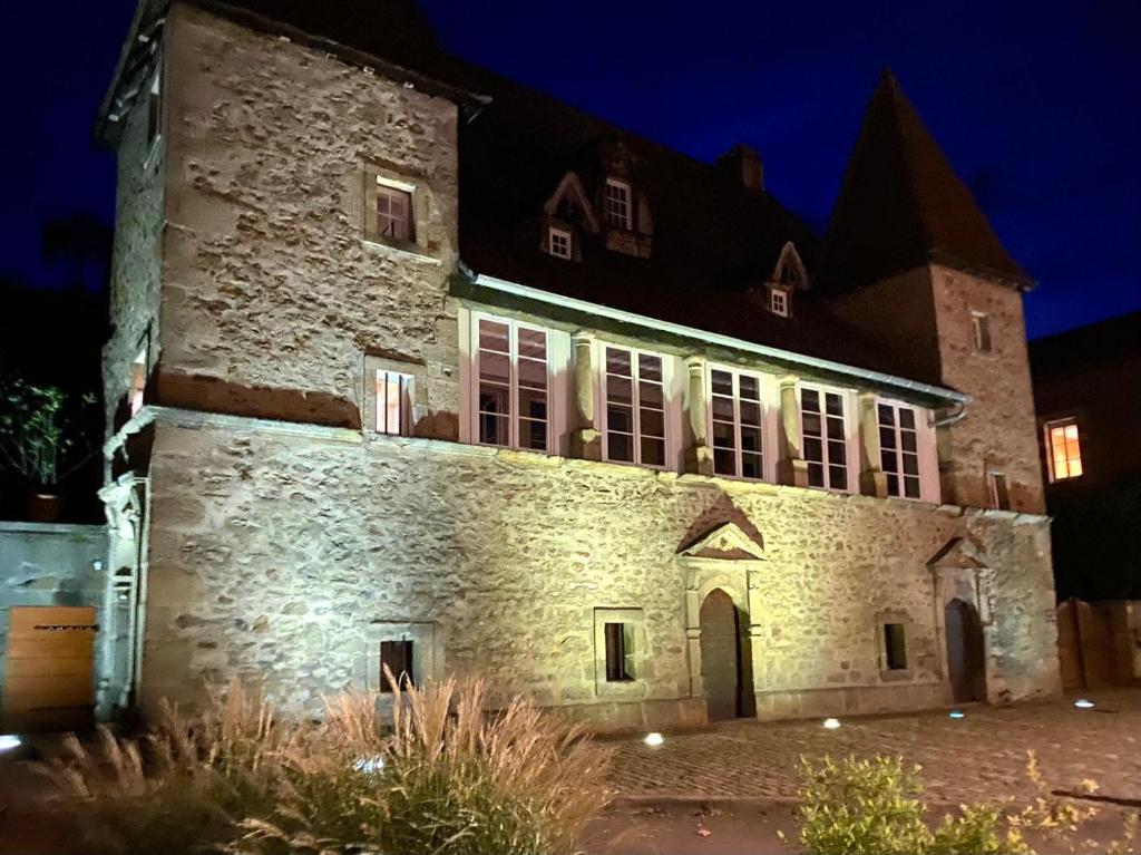an old stone building at night with lights on at La Maison des Templiers in Couches