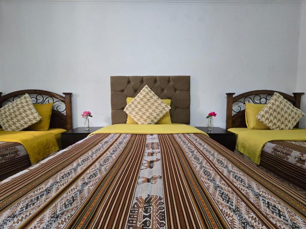 a bedroom with two beds with yellow bedspreads at Magnolia Andina Hostel in Cusco