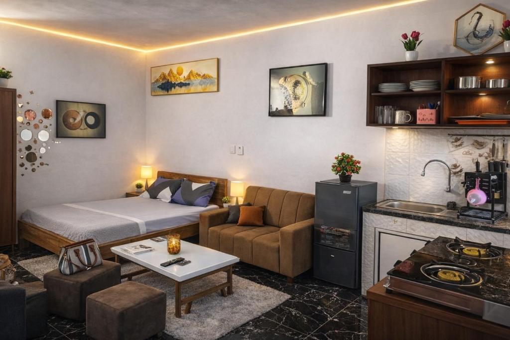 a living room with a bed a couch and a kitchen at Les studios meublés d'Angré in Abidjan