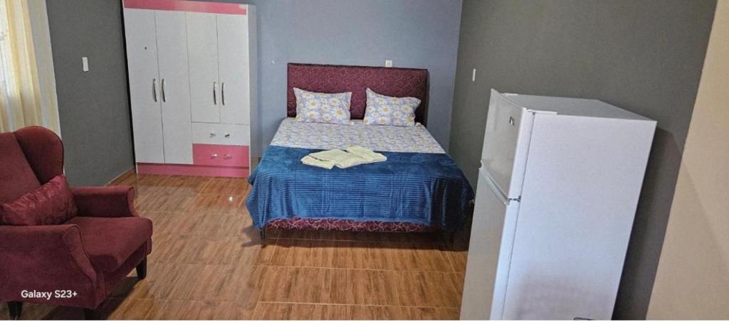 a small bedroom with a bed and a chair at Residencia Guadalupe in Colonia Río Verde