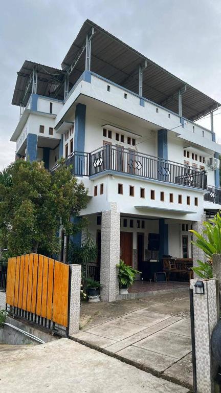 a large white building with a fence in front of it at Chik Nories in Labuan Bajo