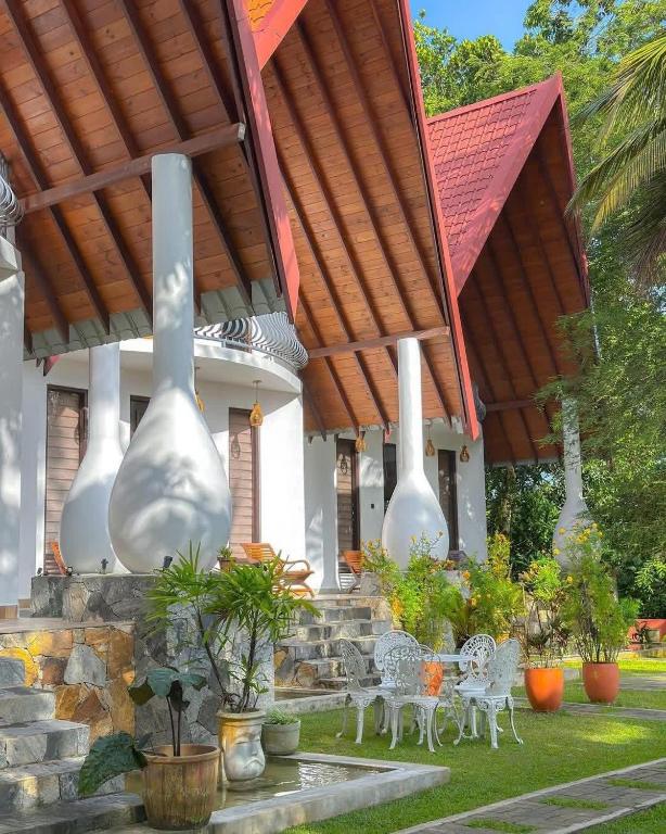 a patio with white tables and chairs under a pavilion at Mantara in Matara