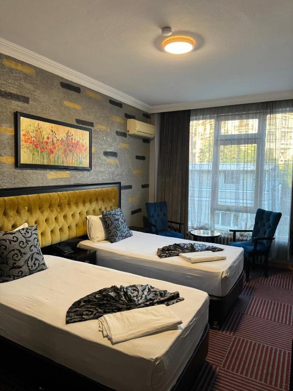 a hotel room with three beds in a room at Ankara Efes Otel in Altındağ