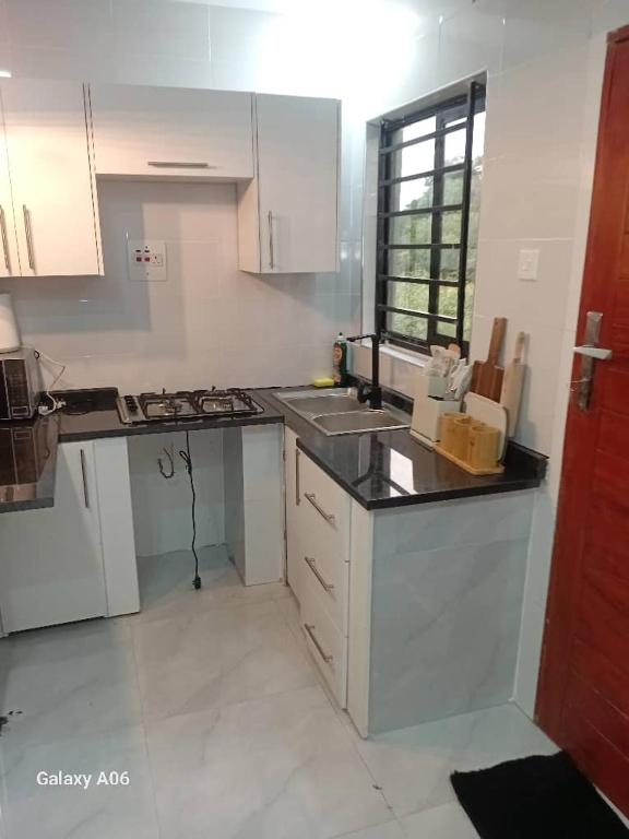 a kitchen with white cabinets and a counter top at Wamis serviced apartments in Solwezi