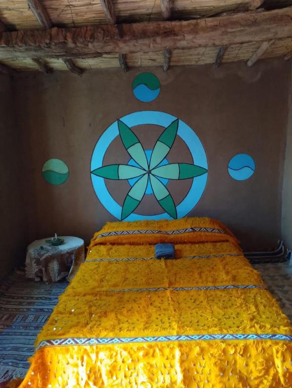 a bedroom with a large bed with a painting on the wall at Authentic Sahara with Locals in Tagounite