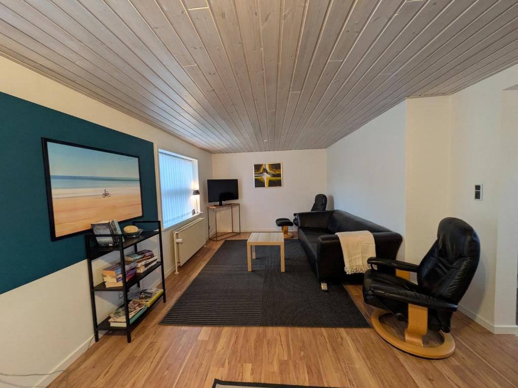 a living room with a flat screen tv and a couch at Hus 5 personer in Hjørring