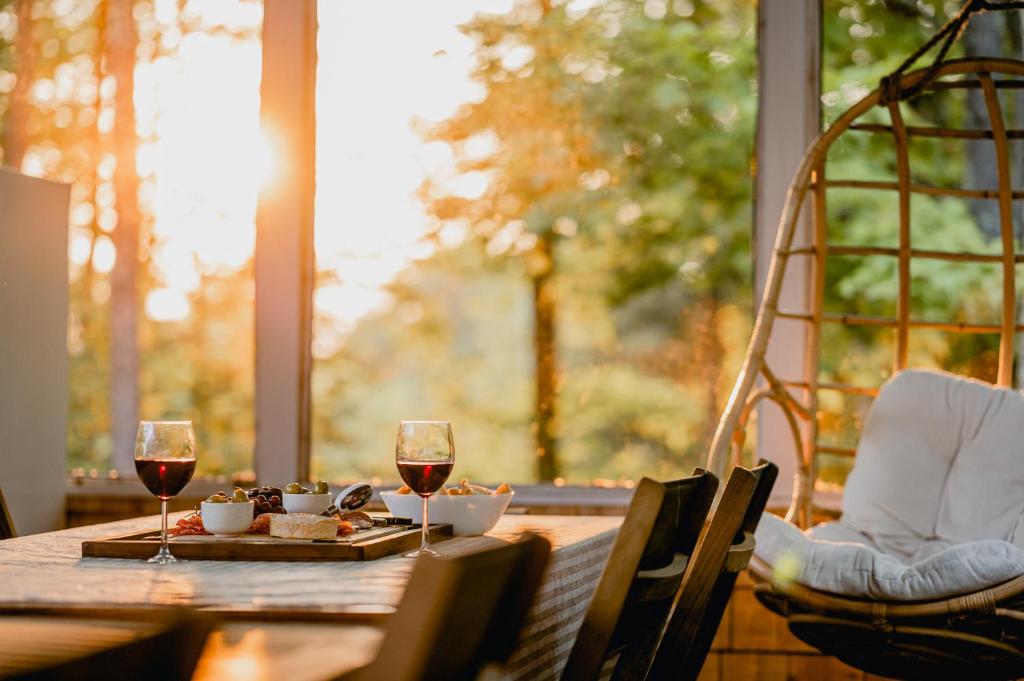 a wooden table with two glasses of red wine at Chalet Memphrémagog Ski Spa, Étang in Mansonville