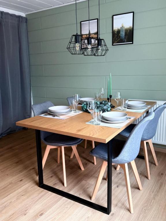 a dining room table with blue chairs and a wooden tableablish at Apartment 18 in Kurort Oberwiesenthal