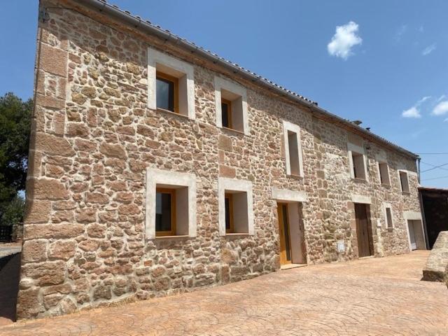 a large stone building with windows on it at Cal Perico in San Pedro Sallavinera