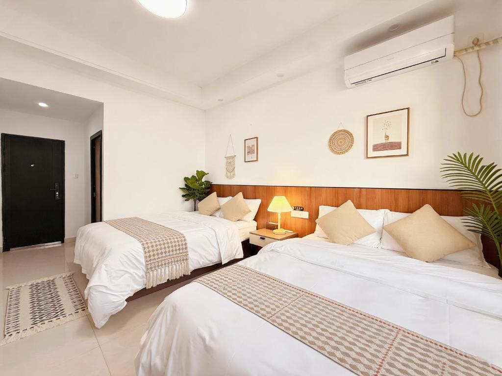 two beds in a room with white walls at Damao Holiday shanghai pvg 24hFREE shuttle bus in Shanghai