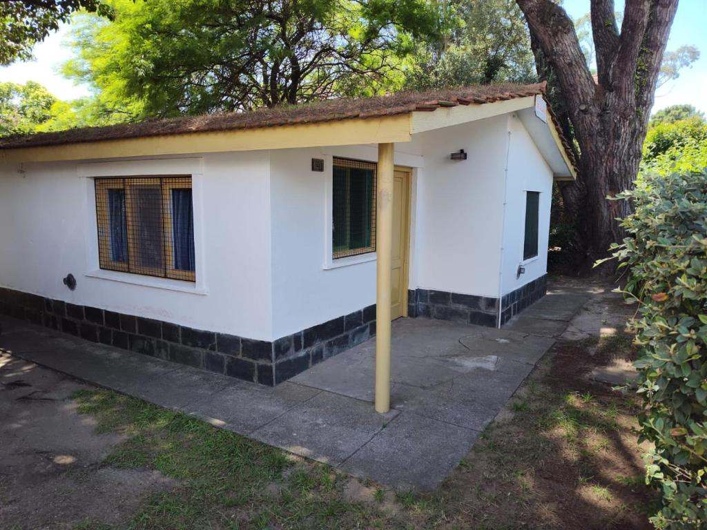 a small white house with a yellow pole at Casa Centrica 5 Huésped in Pinamar
