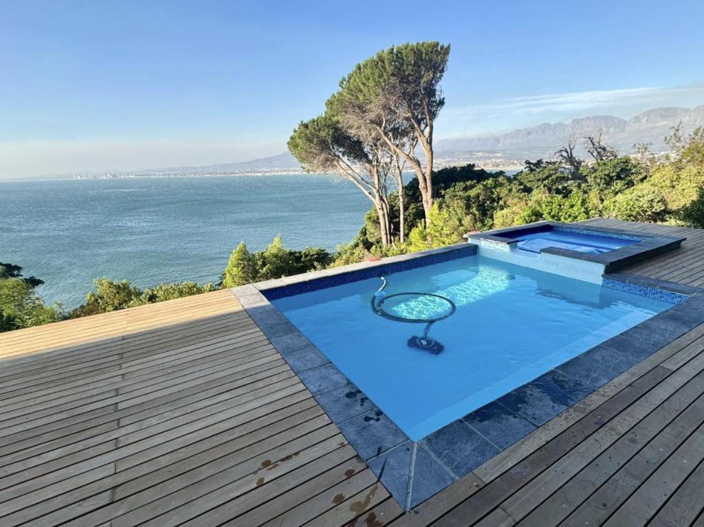 a swimming pool on the roof of a house at Oceana Views in Gordonʼs Bay