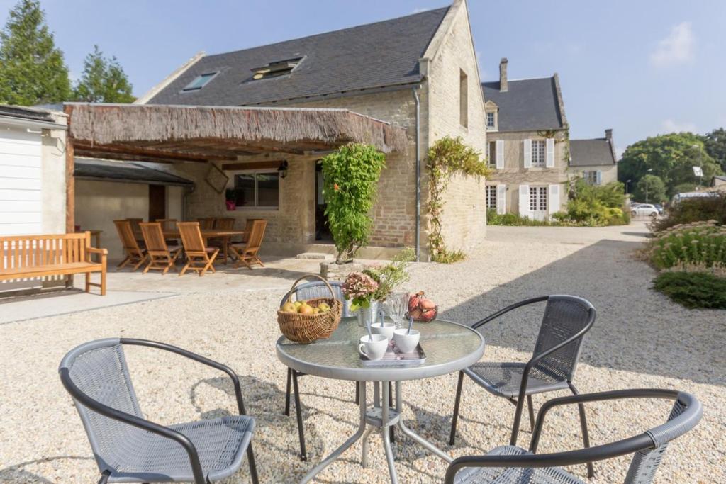 a table and chairs in front of a house at Le Relais des Flâneurs in Thaon