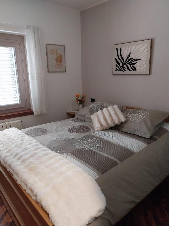 a large bed in a bedroom with a window at Bella Vista casa vacanze in Grosio