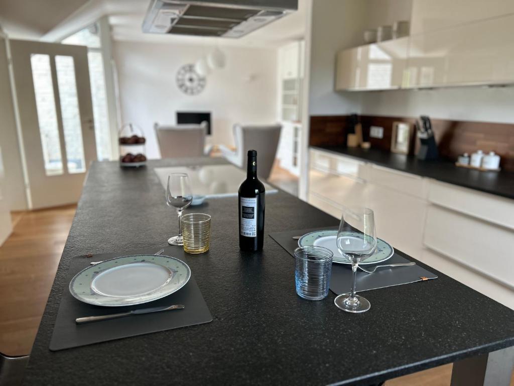 a table with a bottle of wine and two glasses at Gemütliche Wohnung in Baldham bei München in Vaterstetten