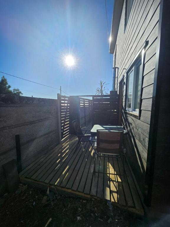 a wooden deck with a table and chairs on it at Refugio Titi3 in Coronel