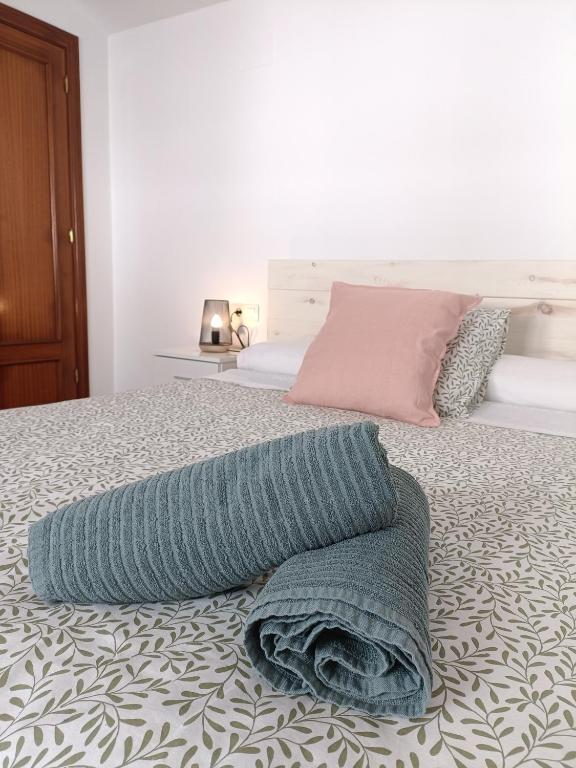 a bed with a blue blanket on top of it at Aracena Centro by Aracena Rural Exp in Aracena