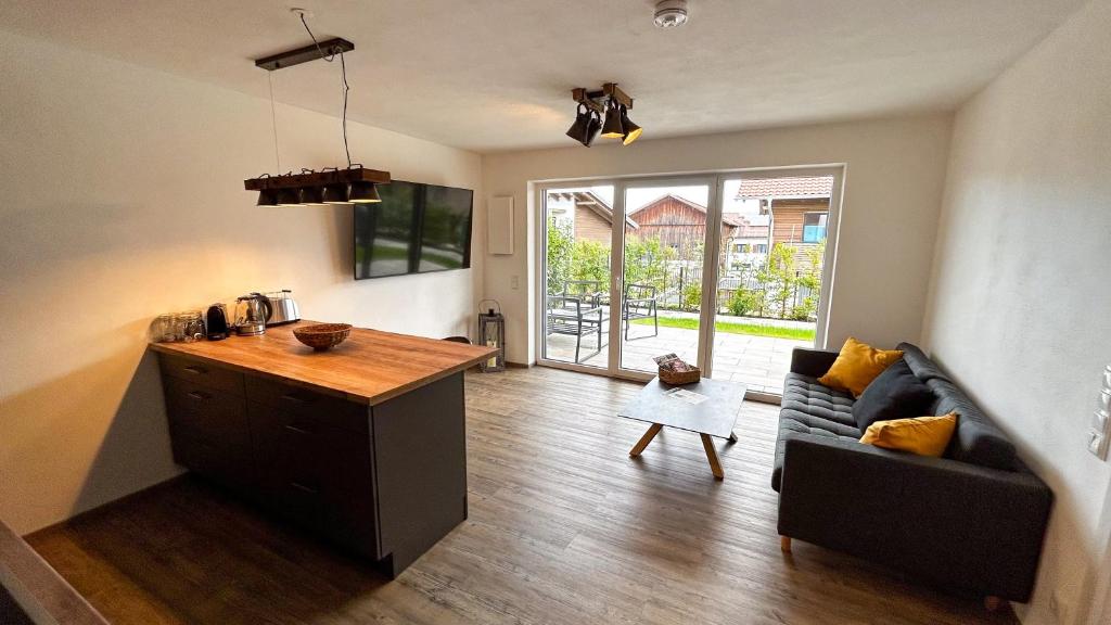 a kitchen and living room with a couch and a table at Ferienwohnung Wiesenweg - Aktiv im Allgäu in Seeg